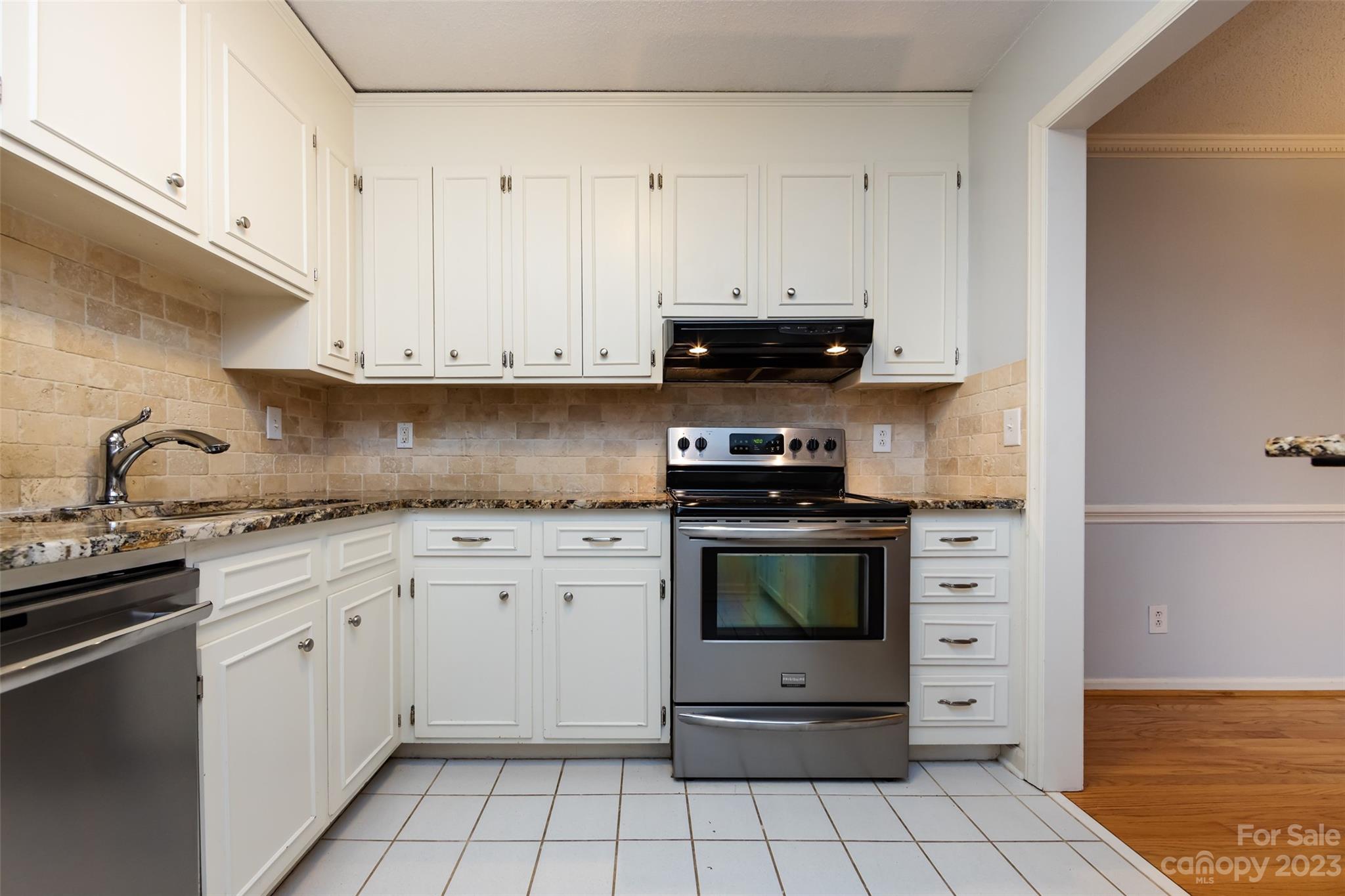 1336 Queens Road Charlotte, NC 28207 - Photo 22 of 36 a kitchen with stainless steel appliances granite countertop a stove a sink and white cabinets