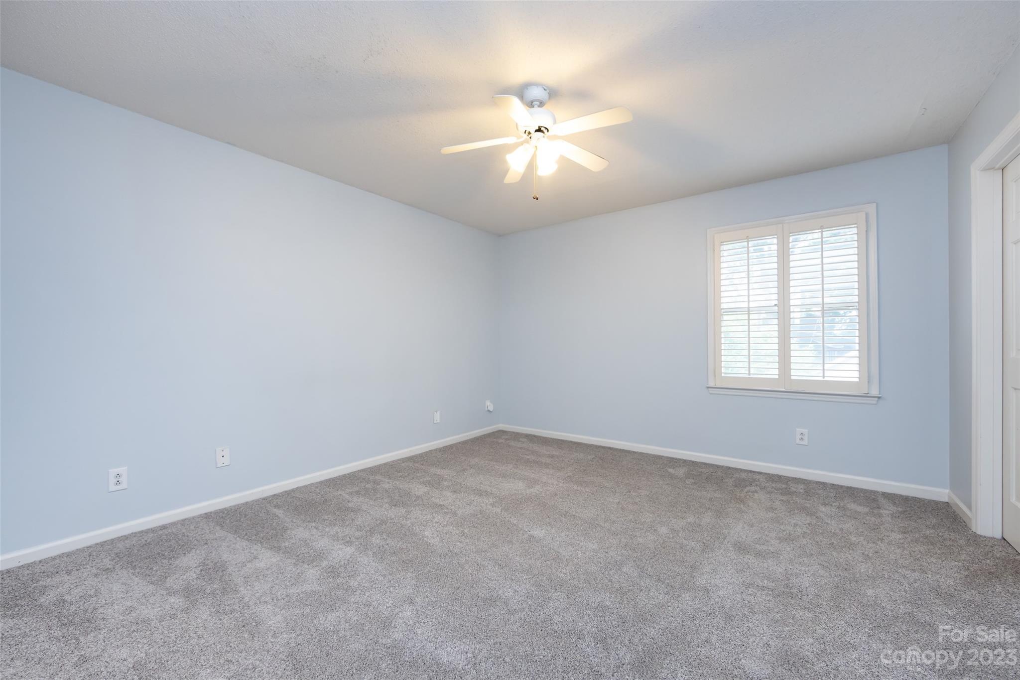 1336 Queens Road Charlotte, NC 28207 - Photo 24 of 36 an empty room with windows and chandelier fan