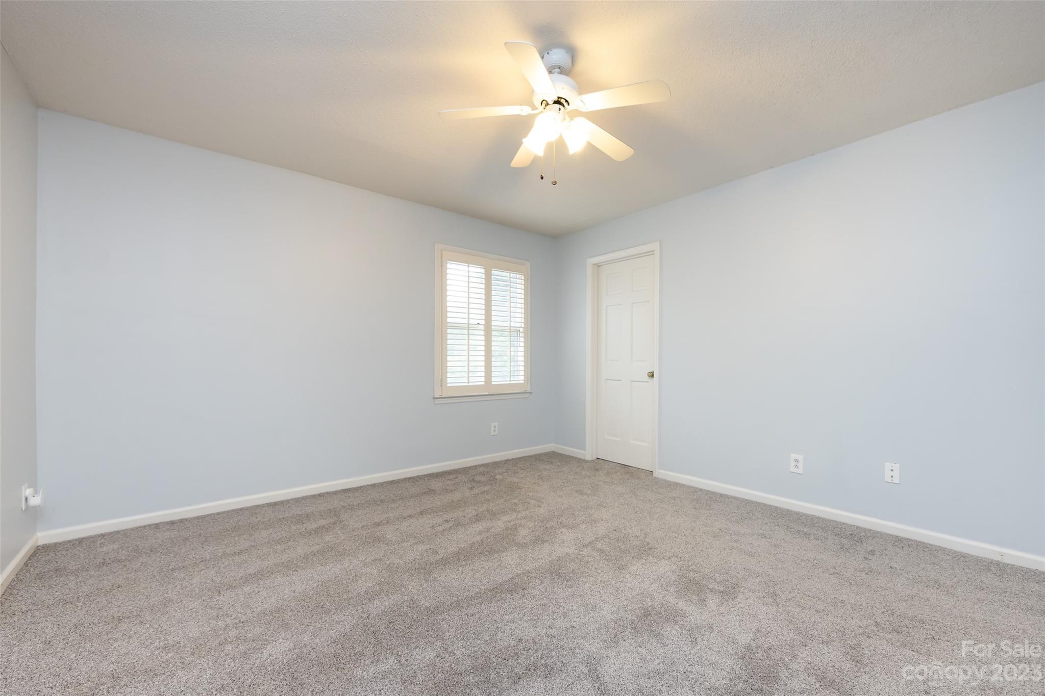 1336 Queens Road Charlotte, NC 28207 - Photo 25 of 36 an empty room with windows and chandelier fan
