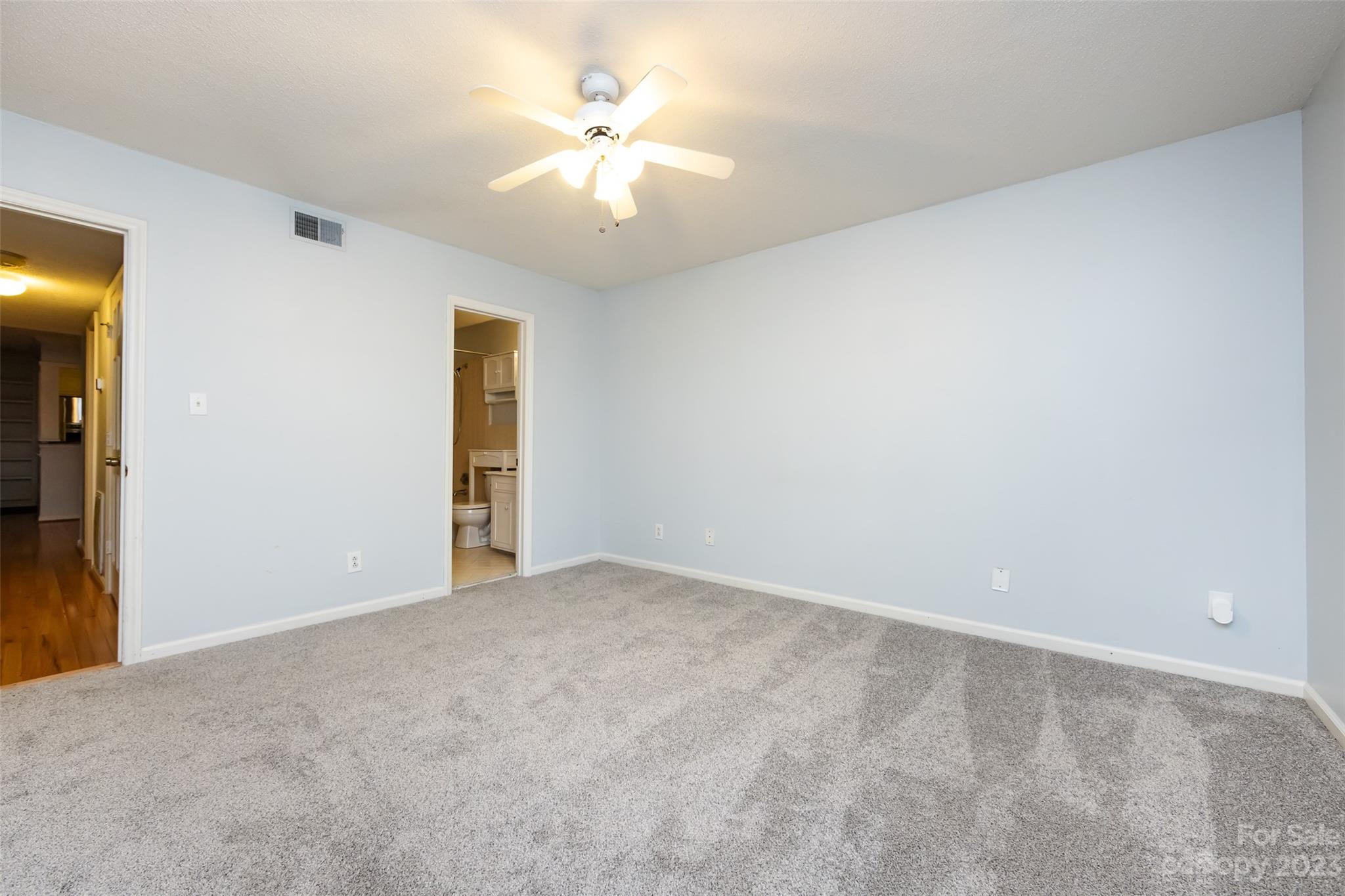 1336 Queens Road Charlotte, NC 28207 - Photo 27 of 36 an empty room with a chandelier fan and windows
