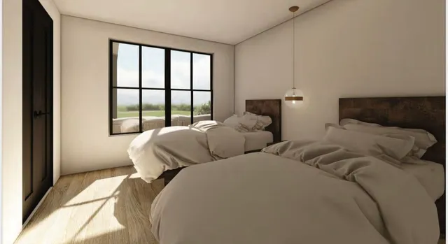a bedroom with two beds and a large window