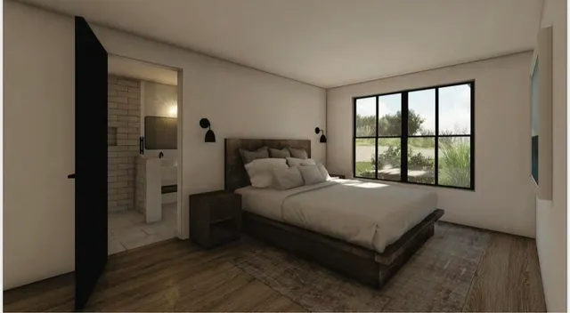 a bed sitting in a spacious bedroom next to a window