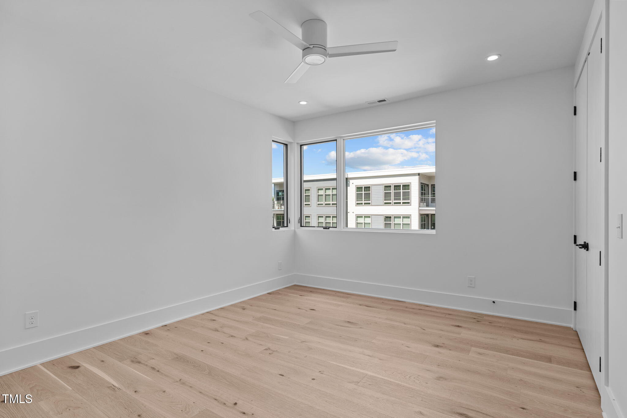 1406 Lyon Street, Unit 101 Raleigh, NC 27608 - Photo 36 of 62 a view of empty room with wooden floor and fan