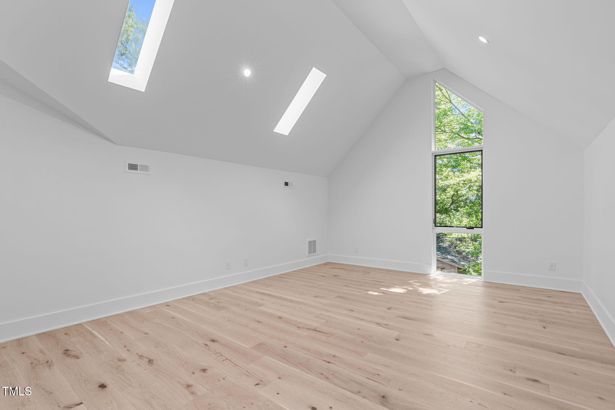 1406 Lyon Street, Unit 101 Raleigh, NC 27608 - Photo 41 of 62 an empty room with wooden floor and natural light