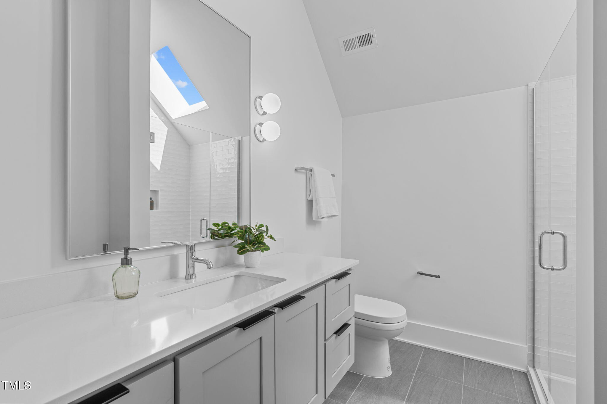 1406 Lyon Street, Unit 101 Raleigh, NC 27608 - Photo 42 of 62 a bathroom with a granite countertop sink a toilet and a mirror