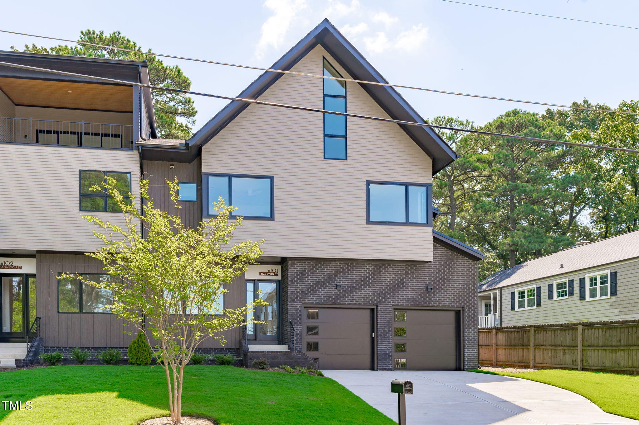 1406 Lyon Street, Unit 101 Raleigh, NC 27608 - Photo 54 of 62 a front view of a house with a yard and garage