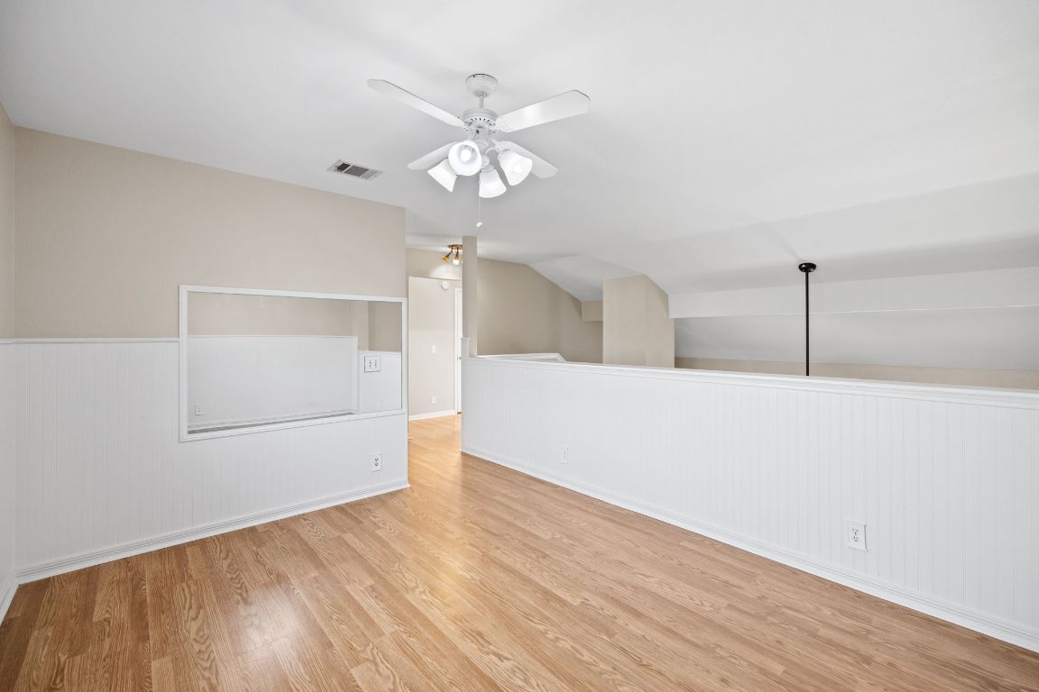 413 Clarks Way Hutto, TX 78634 - Photo 19 of 34 Loft with light wood-style flooring, ceiling fan, lofted ceiling, and wood walls