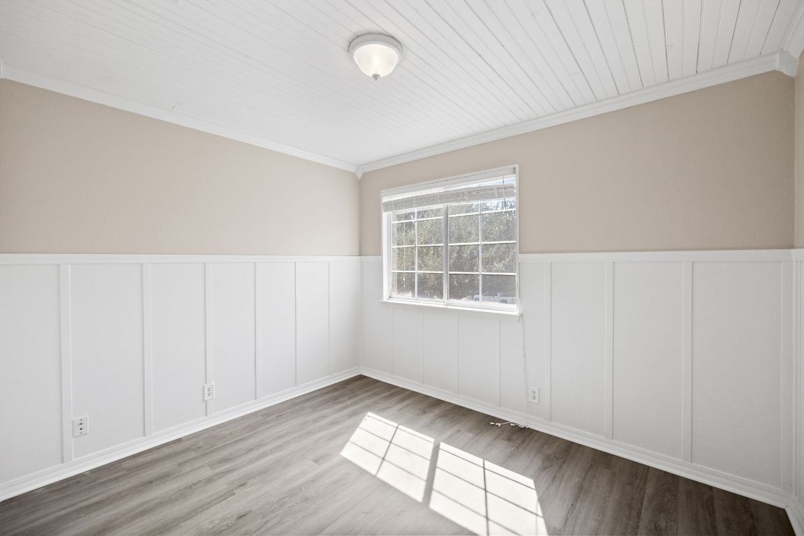 413 Clarks Way Hutto, TX 78634 - Photo 24 of 34 Spare room with wainscoting, crown molding, wood finished floors, and a decorative wall