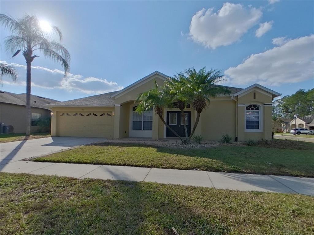 Undisclosed Address Land O Lakes, FL 34638 - Photo 1 of 18 a front view of a house with a yard and garage