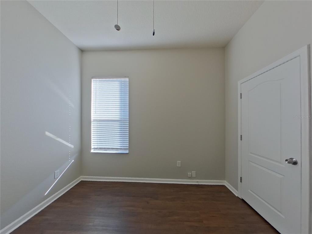Undisclosed Address Land O Lakes, FL 34638 - Photo 11 of 18 an empty room with wooden floor and windows