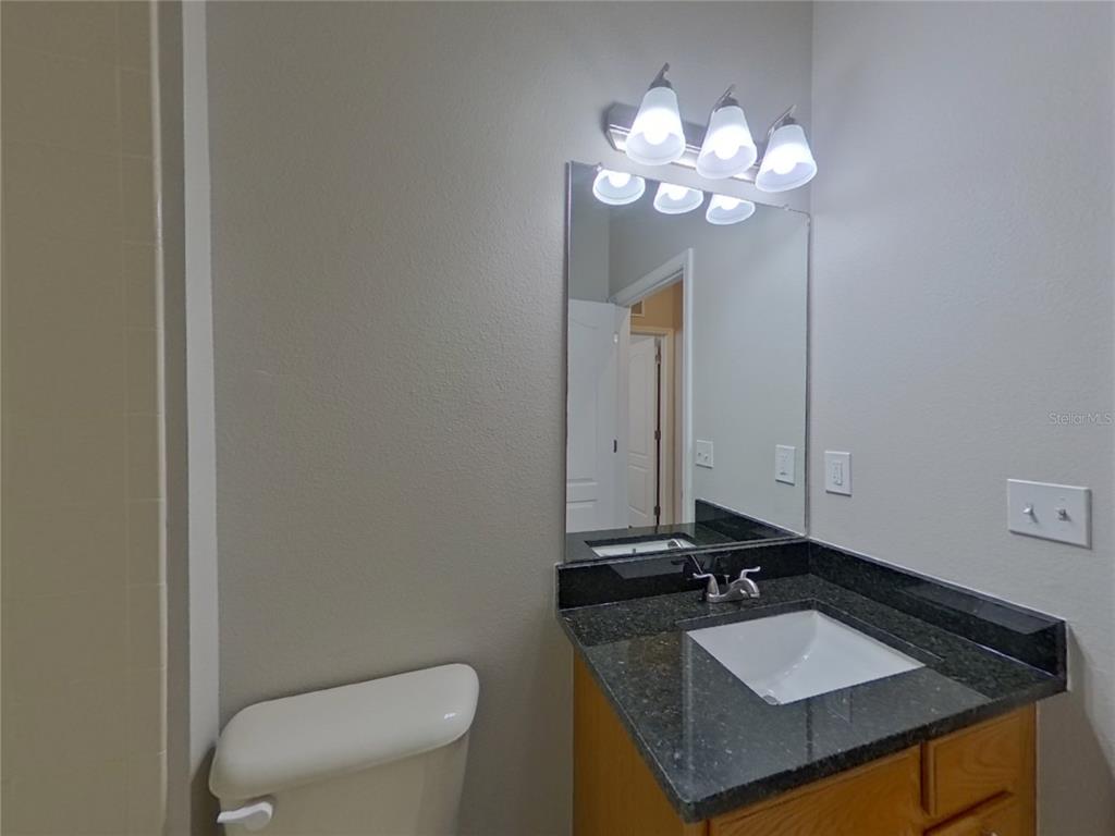 Undisclosed Address Land O Lakes, FL 34638 - Photo 12 of 18 a bathroom with a granite countertop sink and a mirror