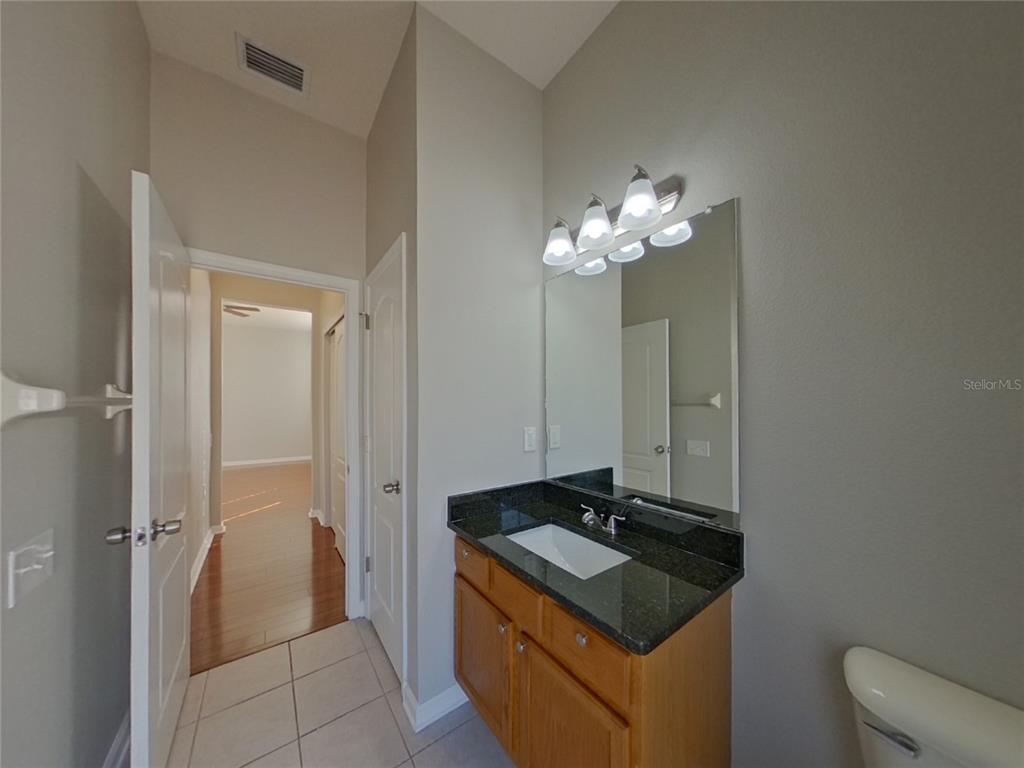 Undisclosed Address Land O Lakes, FL 34638 - Photo 9 of 18 a bathroom with a granite countertop sink a light fixture and a mirror