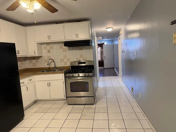 a kitchen with a stove sink and cabinets