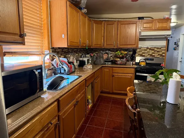 a kitchen with a sink appliances cabinets and a window