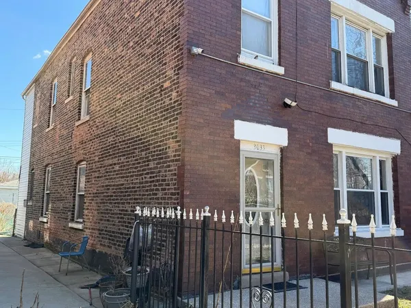 a view of a brick building next to a yard