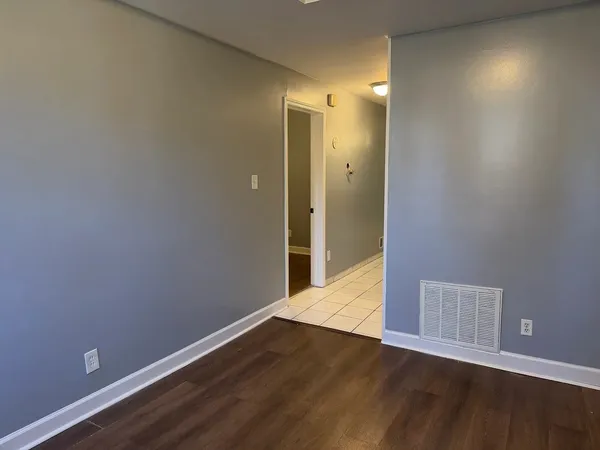 a view of an empty room with wooden floor