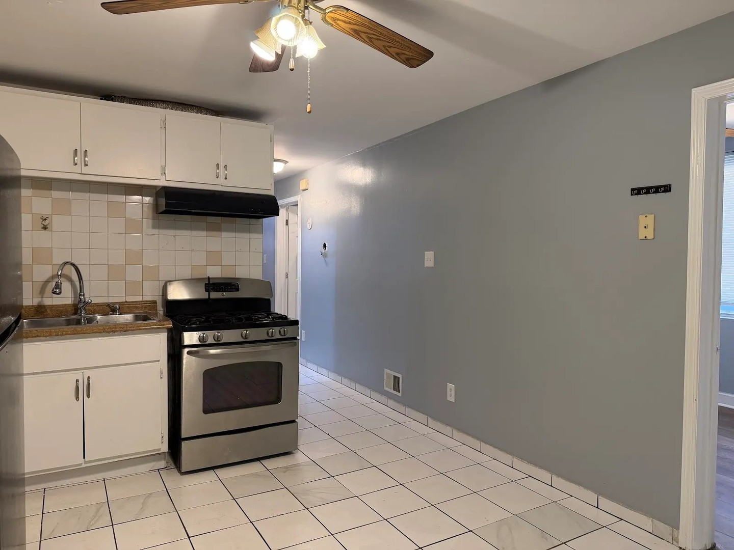 3033 South Kenneth Avenue Chicago, IL 60623 - Photo 10 of 43 a kitchen with granite countertop a stove sink and cabinets