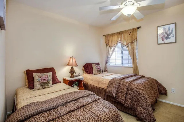 a bedroom with two beds and a chandelier