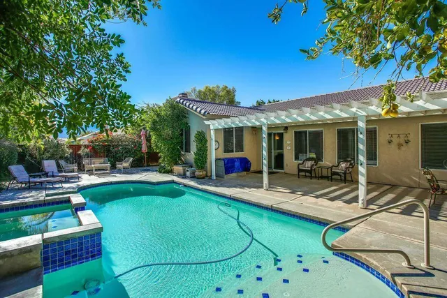 a view of a house with swimming pool and sitting area