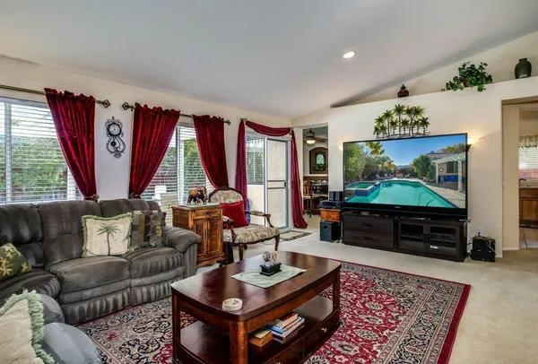 a living room with furniture a flat screen tv and a large window