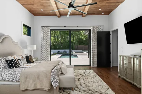 a bedroom with a large bed and a flat tv screen