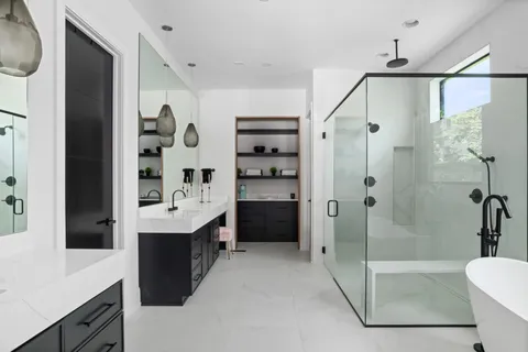 a bathroom with a double vanity sink toilet and shower