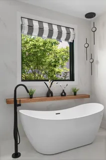 a bath tub sitting in a bathroom next to a window