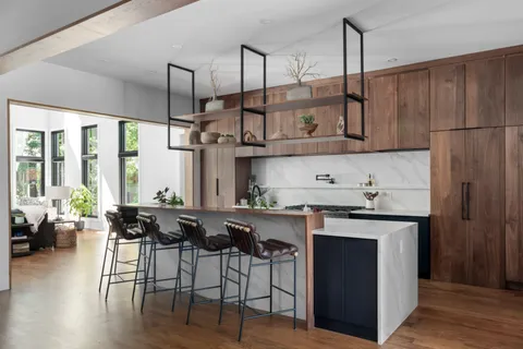 a kitchen with stainless steel appliances granite countertop a stove a refrigerator a sink and white cabinets with wooden floor