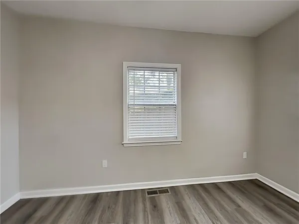 a view of a room with wooden floor and a window