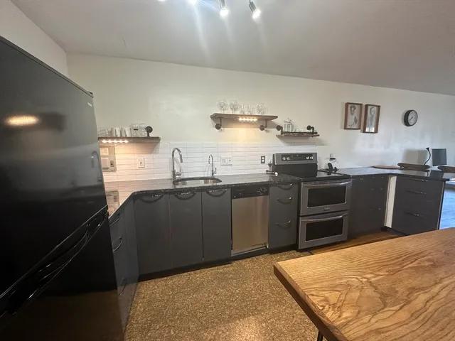 a kitchen with stainless steel appliances granite countertop a sink stove and refrigerator