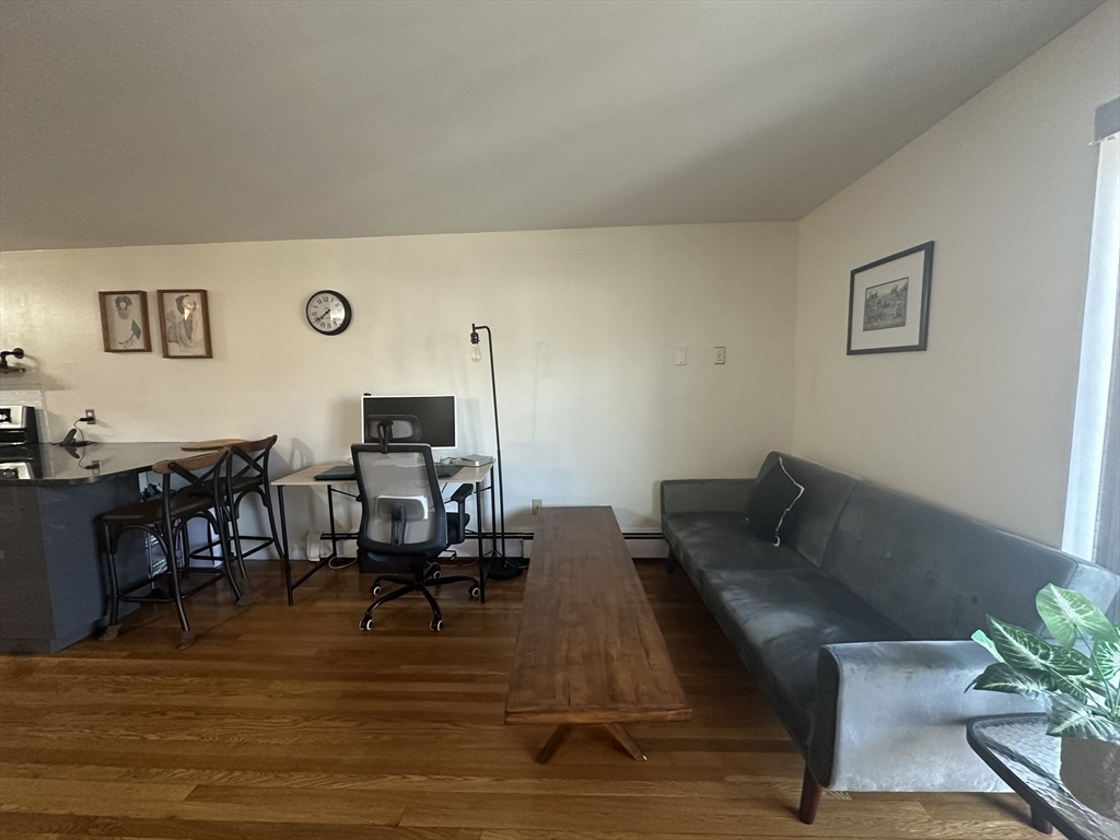 121 Tremont Street, Unit 114 Boston, MA 02135 - Photo 12 of 13 a living room with furniture and wooden floor