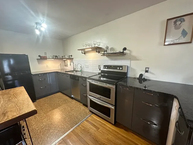 a kitchen with stainless steel appliances granite countertop a stove a sink and a refrigerator