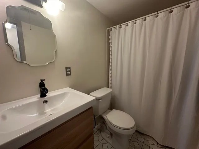 a bathroom with a sink a toilet and a mirror
