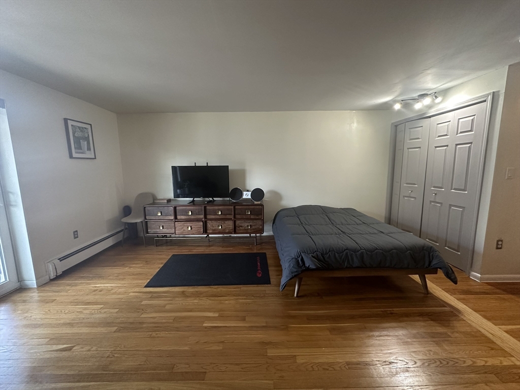 121 Tremont Street, Unit 114 Boston, MA 02135 - Photo 9 of 13 a living room with furniture and a flat screen tv