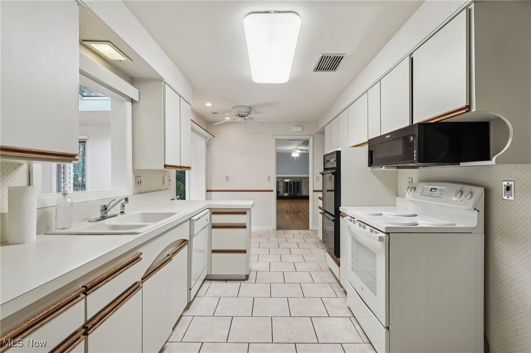 33300 South Woodland Road Cleveland, OH 44124 - Photo 26 of 50 Kitchen with white cabinets, black appliances, light countertops, a ceiling fan, and recessed lighting