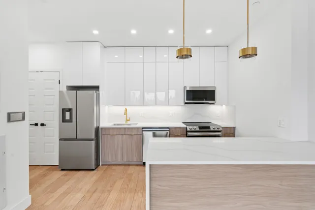 a kitchen with a refrigerator and a stove top oven