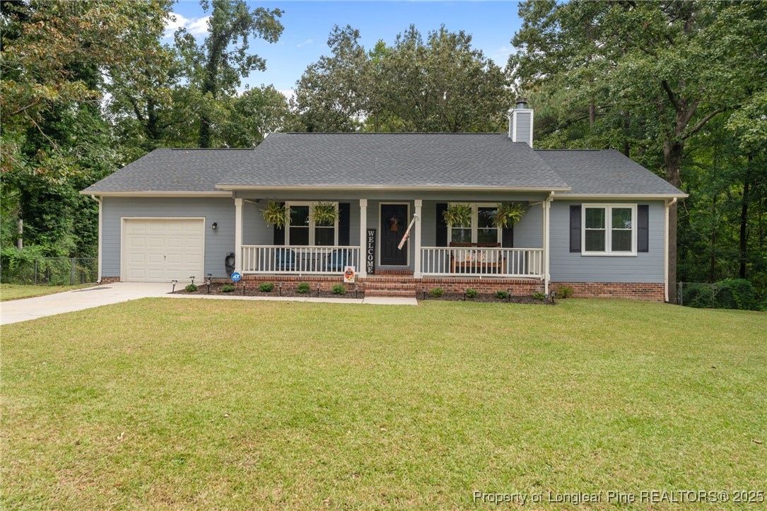76 North Hillside Drive Spring Lake, NC 28390 - Photo 3 of 50 a front view of a house with yard and glass top table and chairs
