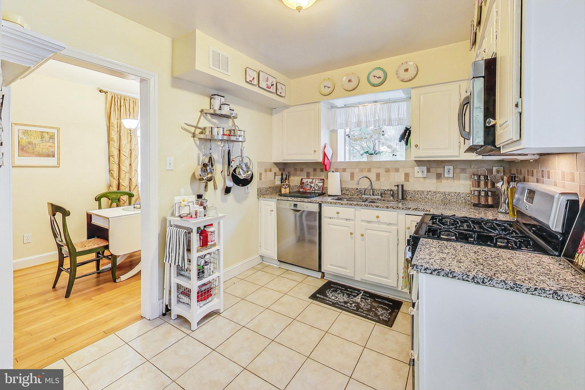 10404 Grandin Road Silver Spring, MD 20902 - Photo 11 of 38 a kitchen with granite countertop a sink a stove and cabinets
