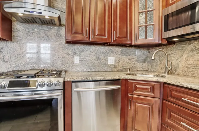a kitchen with granite countertop a stove sink and cabinets