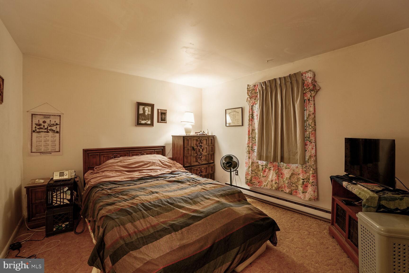 3263 Hawks Hill Road New Windsor, MD 21776 - Photo 10 of 19 a bedroom with a bed and a flat tv screen on a dresser