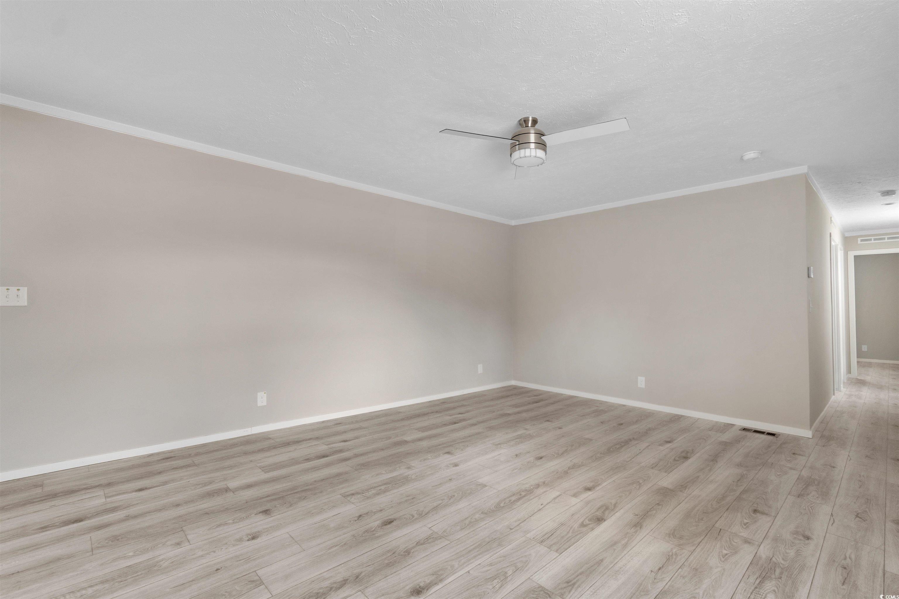 121 Feather Drive Georgetown, SC 29440 - Photo 10 of 40 Unfurnished room featuring light wood-style floors, a textured ceiling, ceiling fan, and crown molding