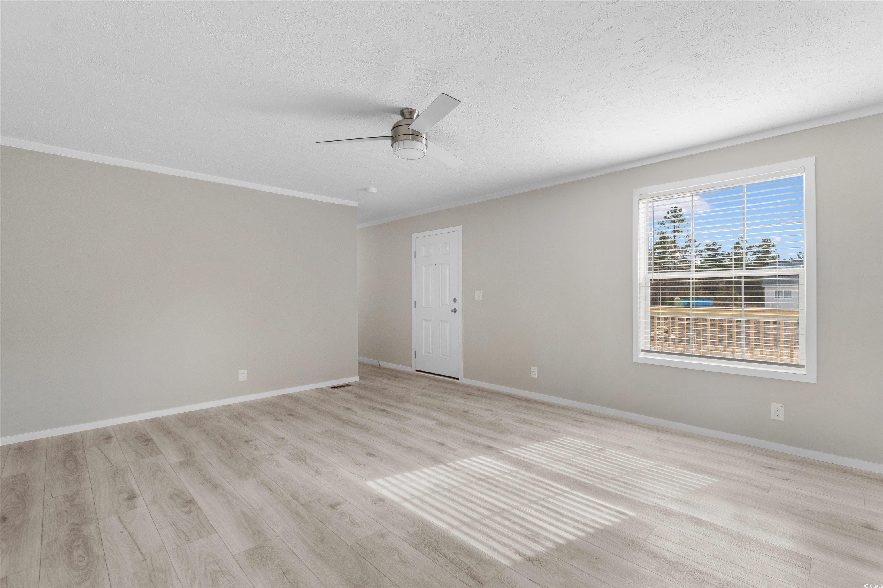 121 Feather Drive Georgetown, SC 29440 - Photo 11 of 40 Spare room with light wood-type flooring, crown molding, a textured ceiling, and a ceiling fan