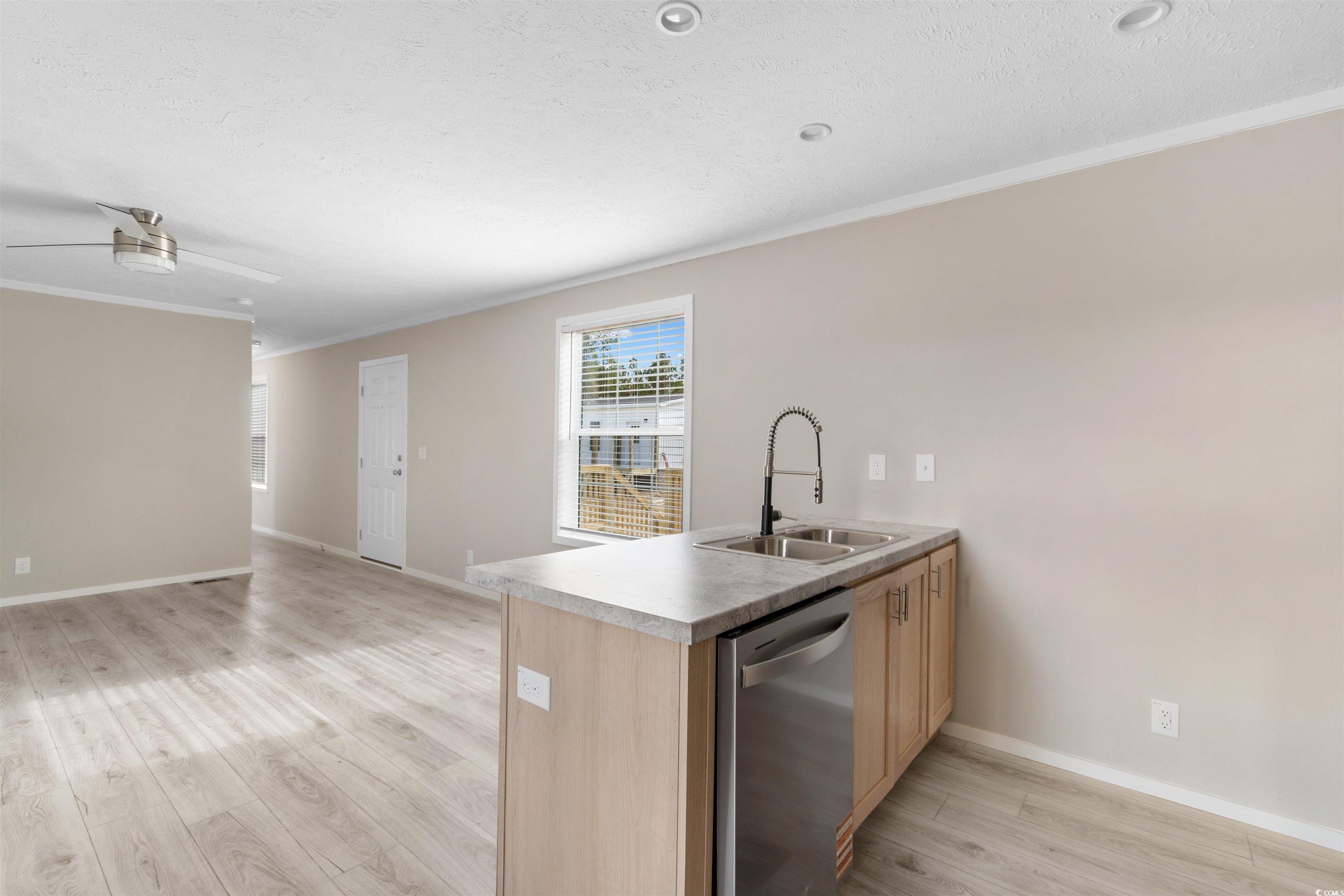 121 Feather Drive Georgetown, SC 29440 - Photo 40 of 40 Kitchen with a peninsula, crown molding, dishwasher, light wood-type flooring, and open floor plan