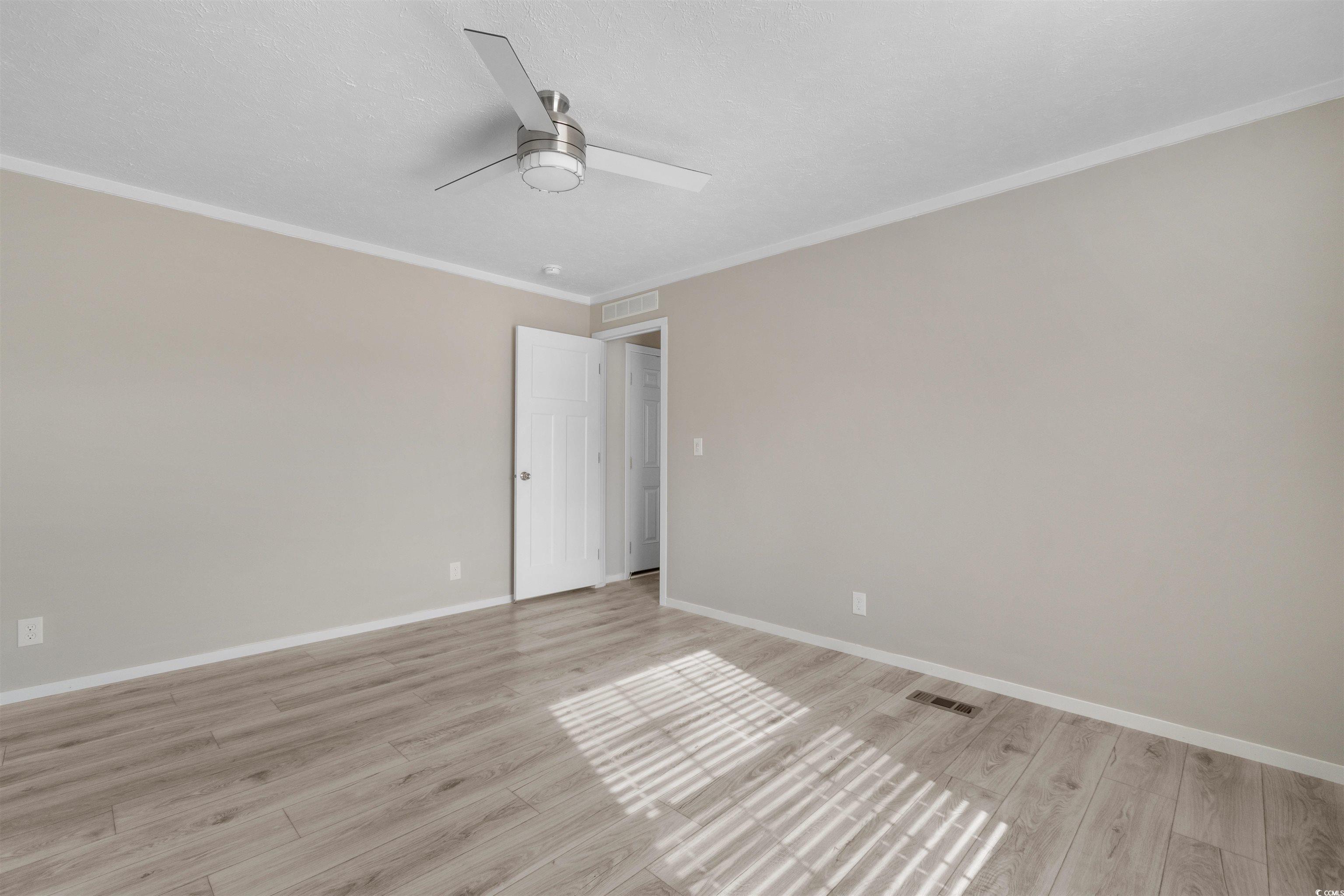 121 Feather Drive Georgetown, SC 29440 - Photo 18 of 40 Spare room featuring crown molding, light wood finished floors, and a ceiling fan