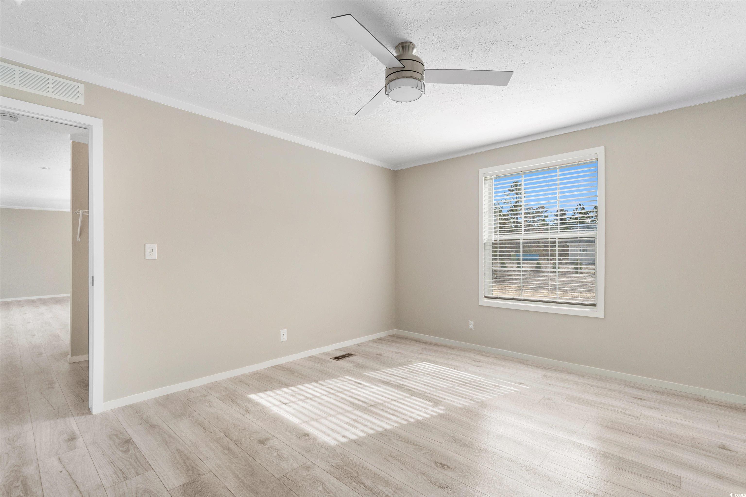121 Feather Drive Georgetown, SC 29440 - Photo 19 of 40 Spare room with light wood finished floors, a ceiling fan, and ornamental molding