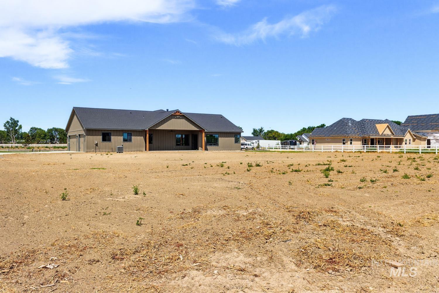 5054 Heritage Drive Marsing, ID 83639 - Photo 36 of 38 New construction residence with an attached two-car garage, dark shingle roof, and a covered patio
