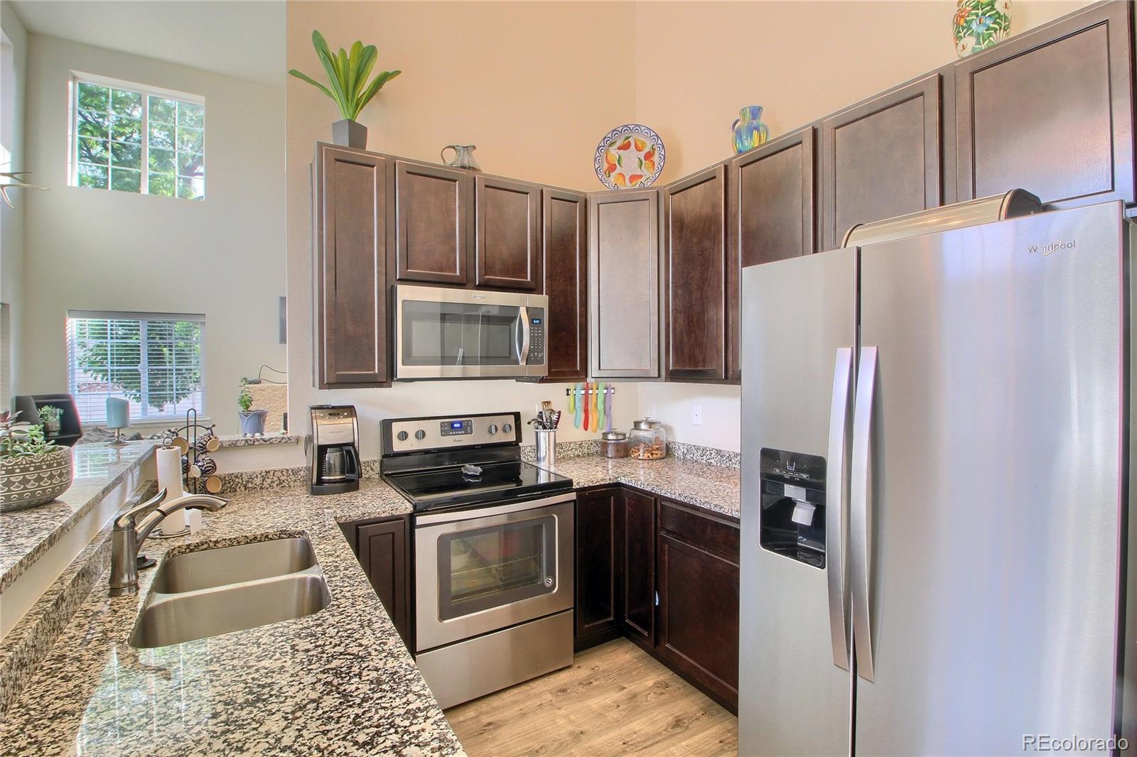 1335 South Chambers Road, Unit 101 Aurora, CO 80017 - Photo 14 of 40 a kitchen with granite countertop a refrigerator stove and sink