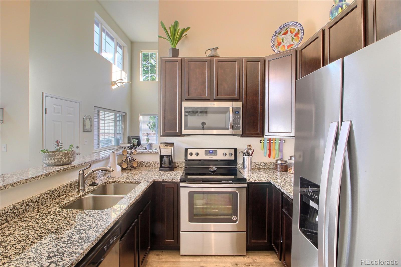 1335 South Chambers Road, Unit 101 Aurora, CO 80017 - Photo 16 of 40 a kitchen that has a sink cabinets counter space and stainless steel appliances