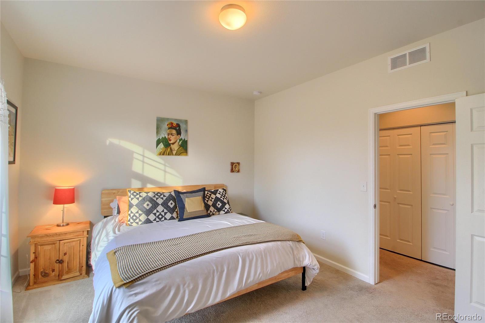 1335 South Chambers Road, Unit 101 Aurora, CO 80017 - Photo 23 of 40 a bedroom with a bed and a lamp