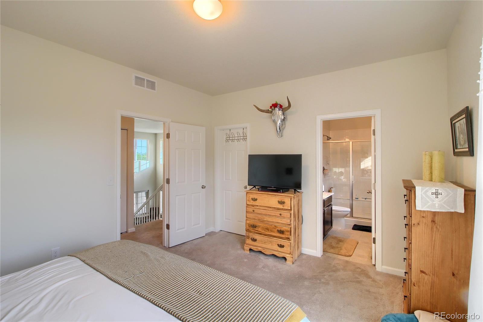 1335 South Chambers Road, Unit 101 Aurora, CO 80017 - Photo 24 of 40 a bedroom with furniture and a flat screen tv